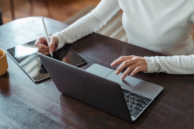 rockbridge-property-manager-sitting-at-desk-on-laptop-writing-notes