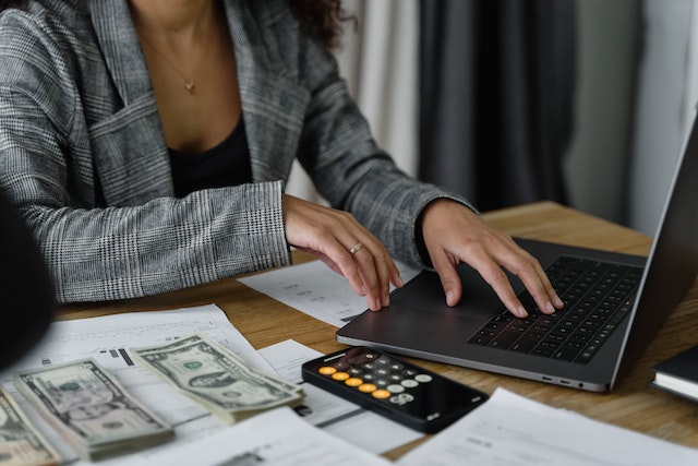 landlord-sitting-at-desk-on-laptop-with-money-beside-them